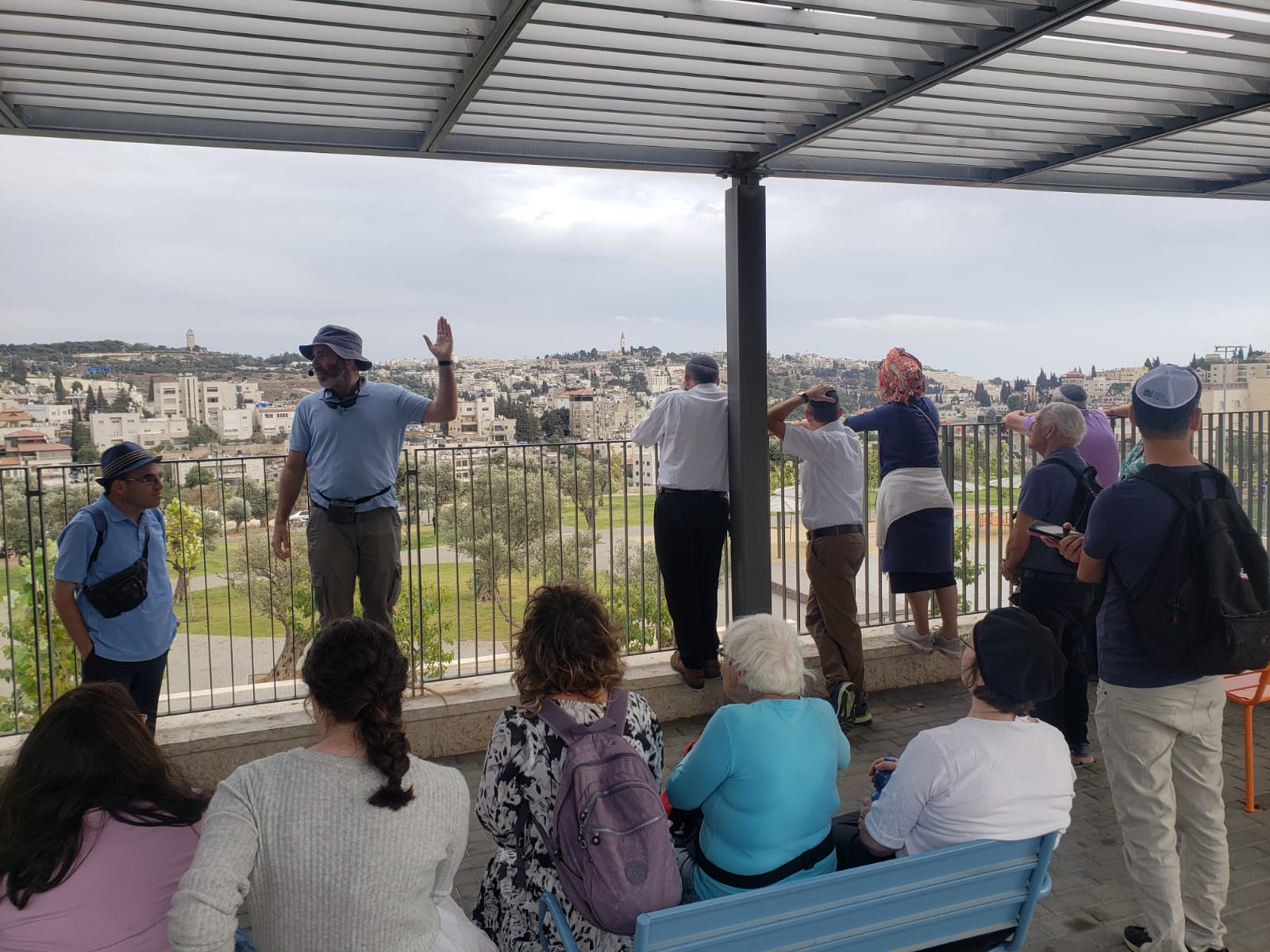 מדריך מסביר לקבוצת מטיילים על רקע נוף ירושלים